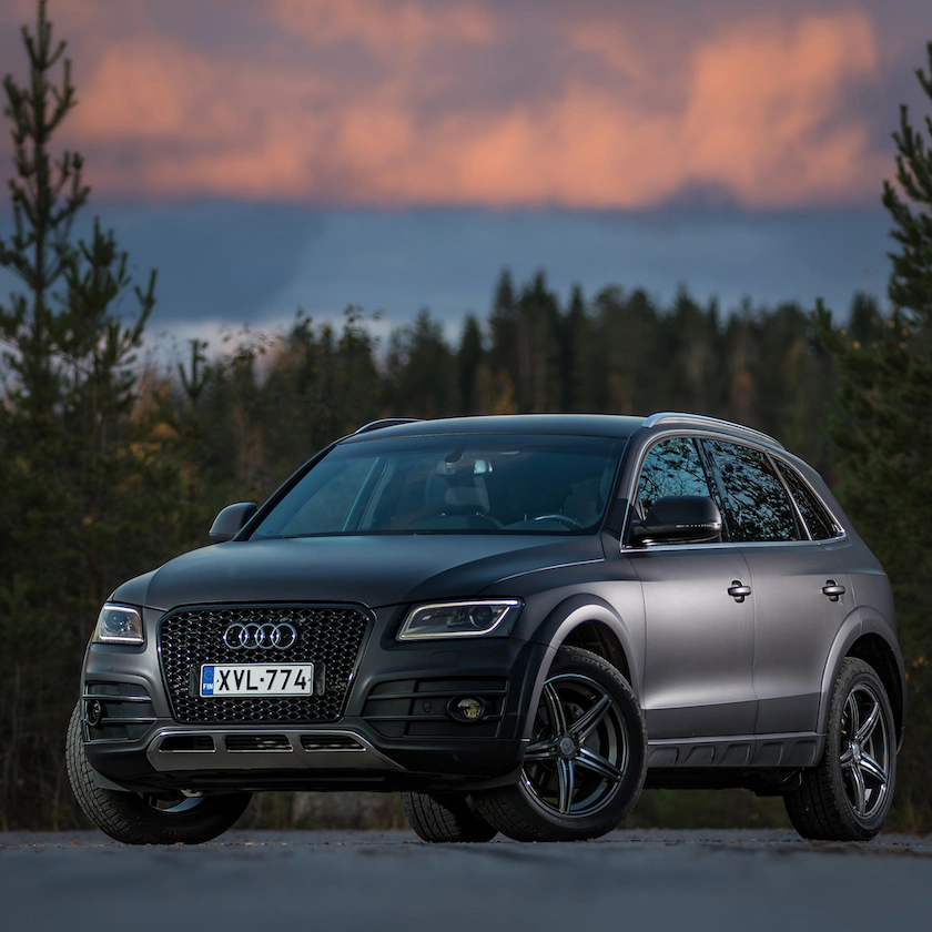 Audi-merkkinen katumaasturi kuvattuna auringonlaskun jälkeen.