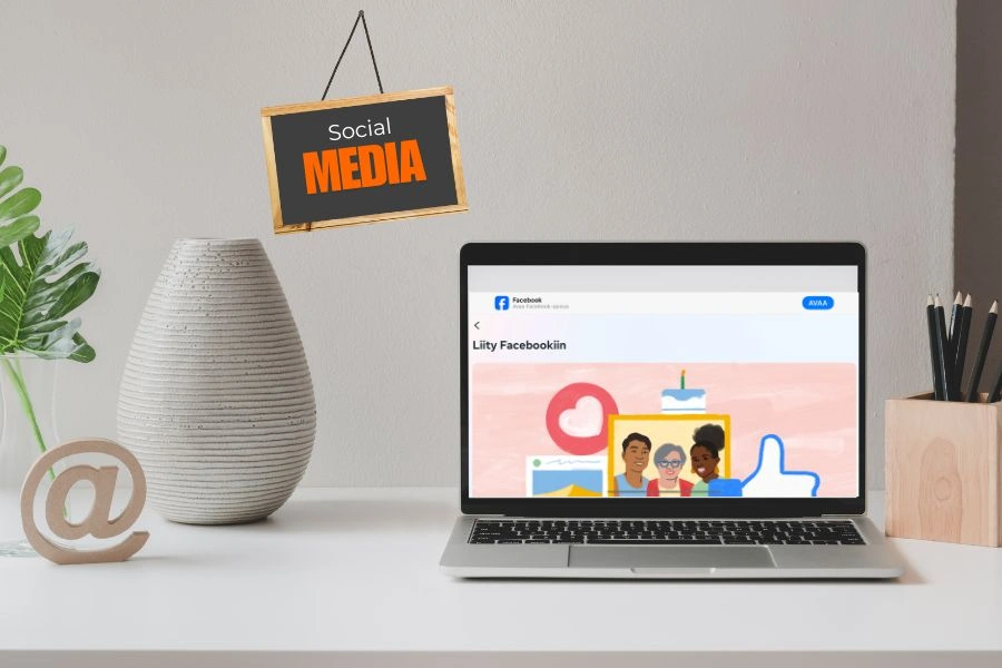 Työpöytä jossa on läppäri ja sosiaaliseen mediaan liittyviä asioista.